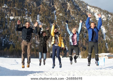 Family in a and outdoor winter setting. Jumping in joy! Slight motion bluriness is intended.