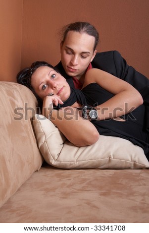 Young couple chilling on a couch at home. Both dressed up nicely.