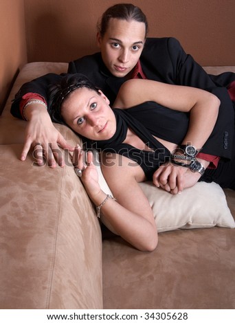Young couple chilling on a couch at home. Both dressed up nicely.