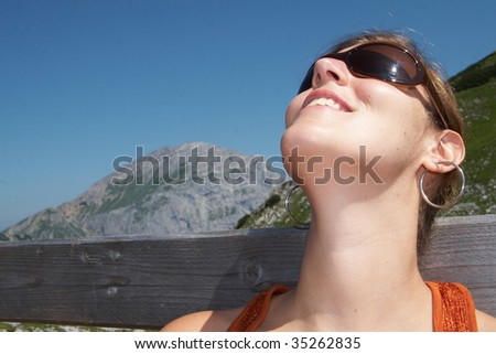 Female hiker relaxing in the sun on top of the mountain.