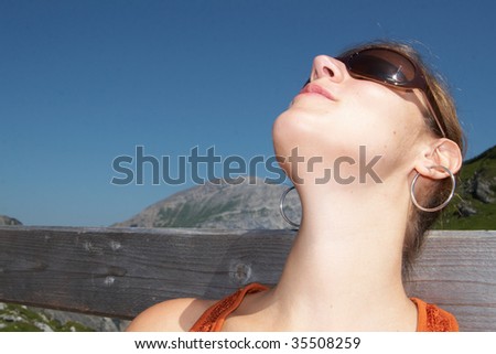 Female hiker relaxing in the sun on top of the mountain.