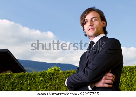 Young realtor in front of a house over blue sky.Young fresh model with longer hair.
