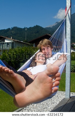 Young cute teenage couple in a hammock enjoying a sunny afternoon.