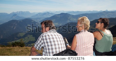 Two older parents with their daughter on top of a mountain