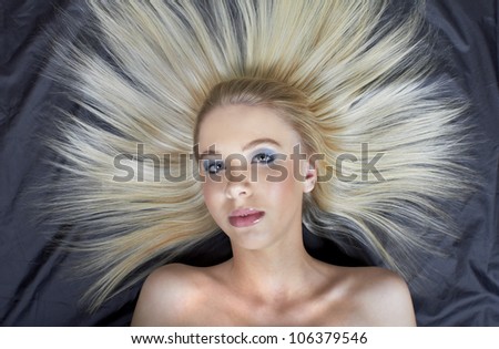 Beautiful Caucasian teenage model with straight combed hair on black background
