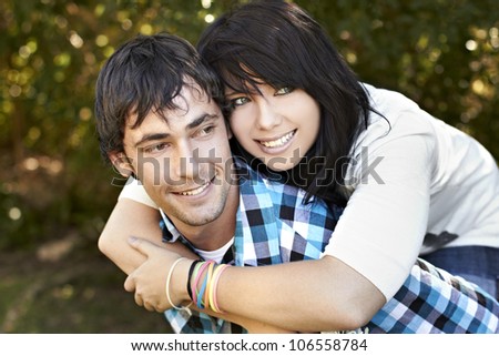 Young lady hugging a young man from behind