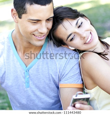 Young romantic couple sharing an audio music device