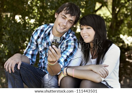 Attractive young couple sharing and listening to music while smiling