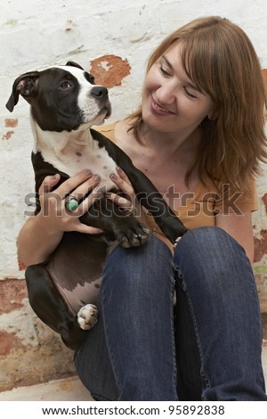 Pit Bull puppy sitting on lap of an attractive young lady