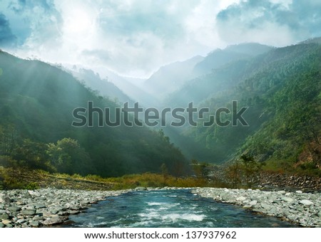 gray blue mountain ranges in the haze and flowing river. Himalaya, Uttarakhand