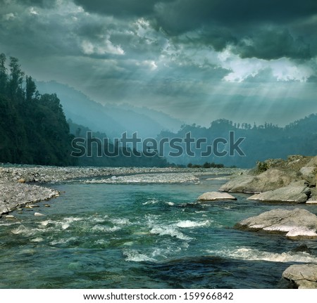 Dark gray cyan cloudy stormy sky over mountain river in the Himalayas