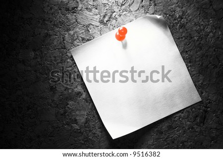 Office paper pinned on a cork board with a red pin. Contrast creative image in special light