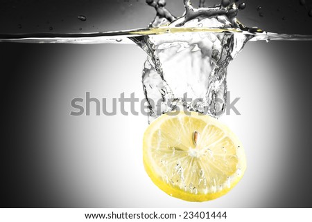 Abstract water background. Yellow lemon falling in water with splashes