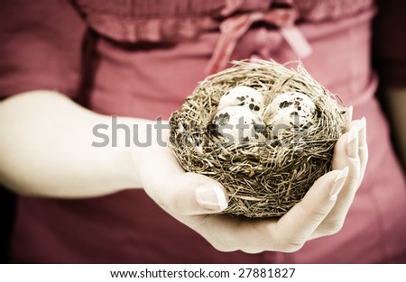 Young woman holding a bird nest in her hand. Conceptual environmental image