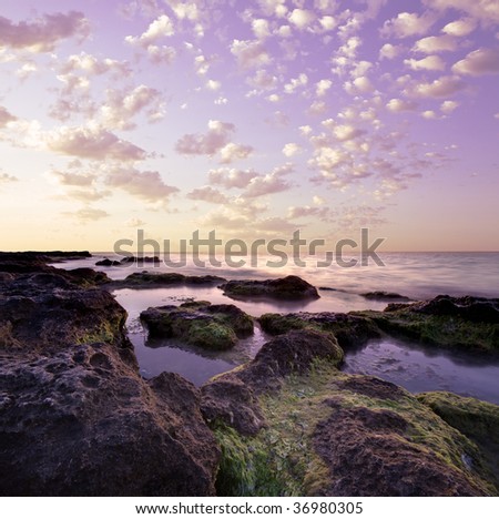 Beautiful purple colors wild rocky lagoon at tranquil ocean and with autumn sky above. Crop image as you wish (according to 23 rule) !