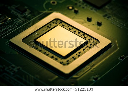 Electronic industry component on green circuit. Chip illuminated with warm light. All trademarks removed, some components position changed. Low aperture shot.