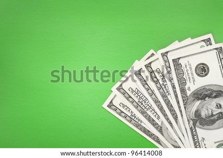 100$ banknotes lying in corner on green simple background.