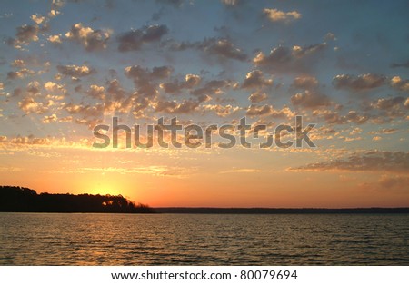 Sunrise Over Quiet Lake.  The sun rises over calm water at Lake Fork in Texas, a favorite lake for bass fishing.