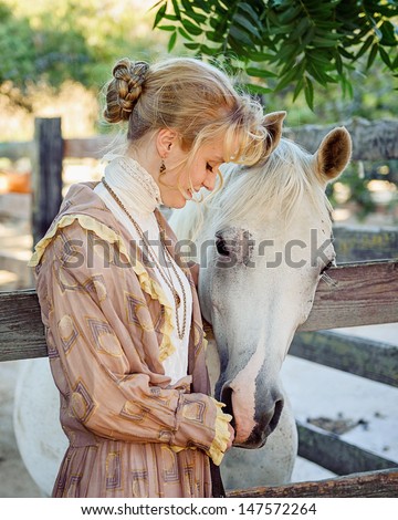 Young Girl dressed in 1800s Vintage Clothing petting horse