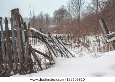 the winter landscape, broken fence in snow