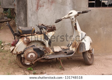 the old, rusty motorcycle on the street