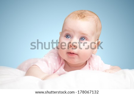 the little girl lies on a pillow - cloud. on a blue background.