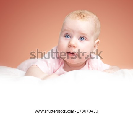 the little girl lies on a pillow - cloud. on a pink background. white place with a bottom for your text