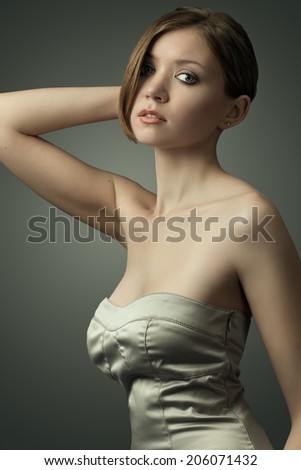 portrait of the young beautiful girl in studio, in a silver dress