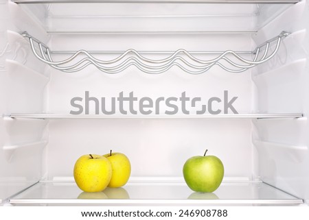 three apples in open empty refrigerator