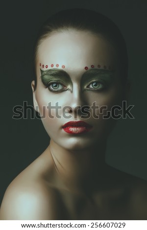 dramatic art portrait of girl. dark green mack-up. on soft background. close up face