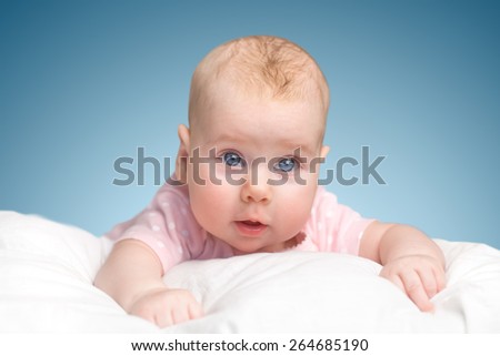 the little girl lies on a pillow - cloud. on a blue background