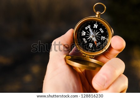 man holding an antique compass to find direction