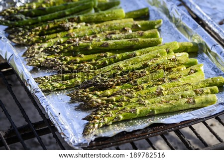 cooking asparagus on an outdoor grill.