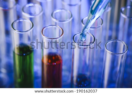 a close up of a an eye dropper and test tubes