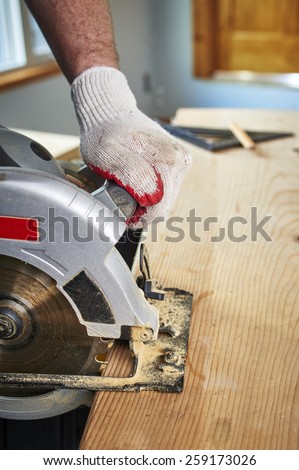 a man using a saw to cut a piece of wood