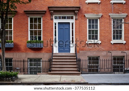 a beautiful brownstone townhouse with a blue door