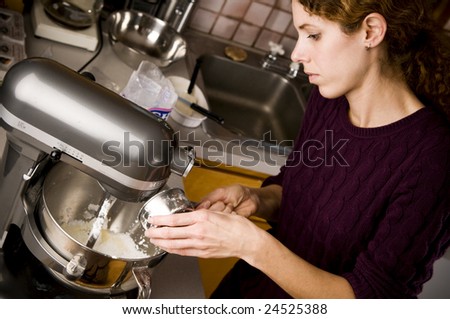 attractive young woman using a mixer in the kitchen