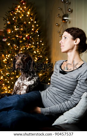 Young woman and her dog at Christmas time.  Focus is on dog\'s face.