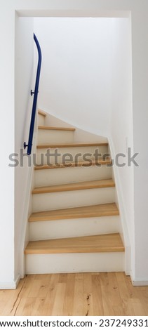 A wooden ladder leading up through white walls