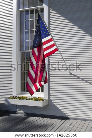 American flag hanging in front of a colonial window frame