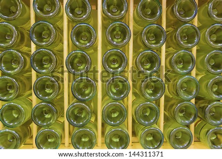White wine bottles stacked on wooden rack