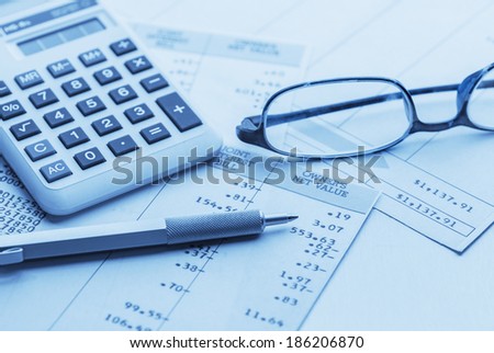 accounting work space with calculator,pen, glasses and profit and loss statements