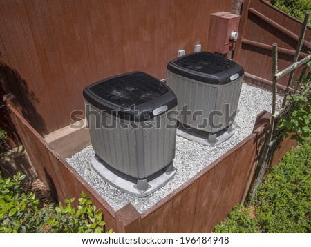 Residential heating and air conditioner compressor units near residential house