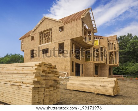 A single family home under construction. The house has been framed and covered in plywood