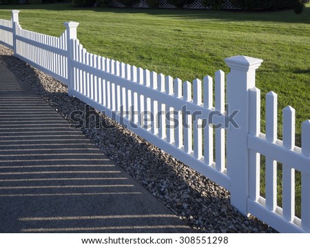 White picket fence that delineates the grass from the pathway