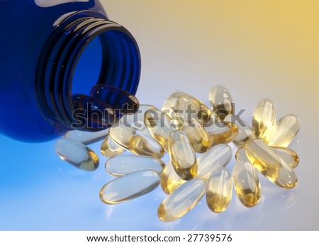 Pills pouring out of blue bottle on orange and blue background