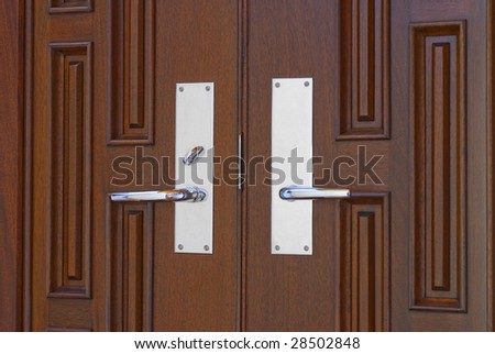 Two door handles to contemporary front door in mahogany