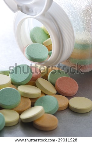Anti acid pills pouring out of clear bottle