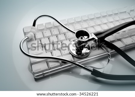 Keyboard and stethoscope back lit on pale green background