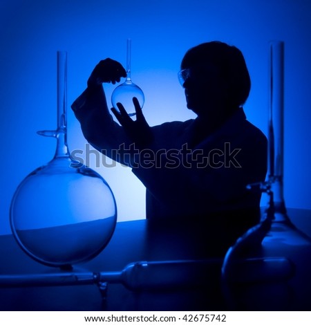 silhouette of female scientist looking at glass flask